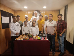 Group of people smiling and posing in front of a table filled with delicious food