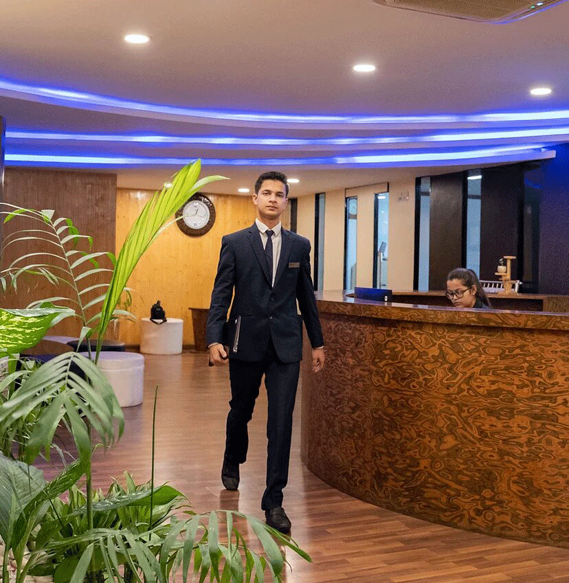 A professional man in a suit walking through a lobby.